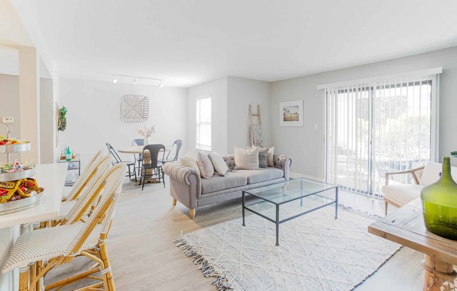 a living room with a gray couch and a glass coffee table