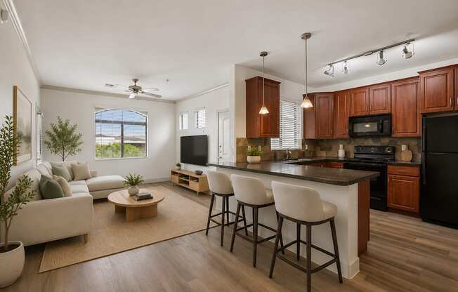 A modern kitchen with dark wood cabinets and a black refrigerator.
