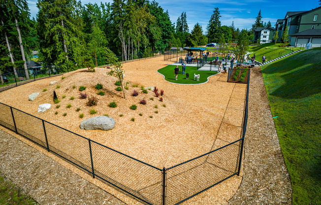 A playground with a fence and a sandbox.