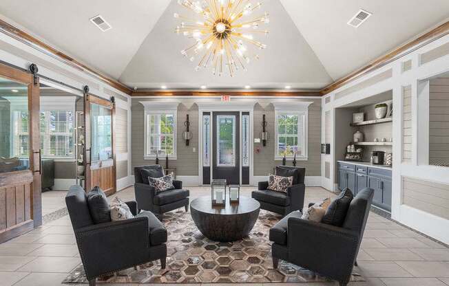 A living room with a large chandelier and a rug.