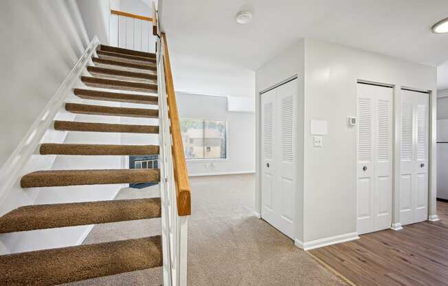 A staircase with a wooden handrail and a carpeted floor.