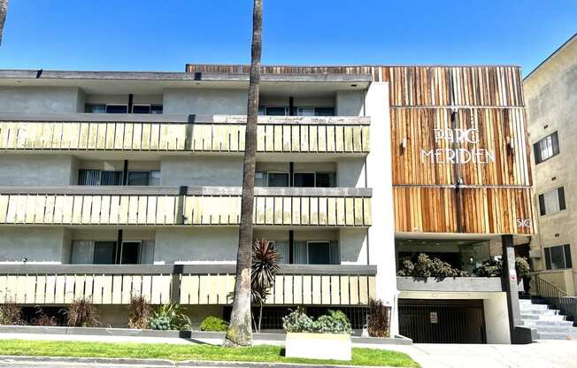 Exterior building view from Normandie St. featuring balconies three floors, garage and lobby entrance  at Parc Meridien, California