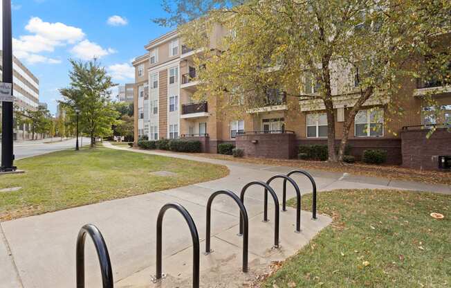 Six bicycle racks on a sidewalk at Ten05 West Trade Apartments.