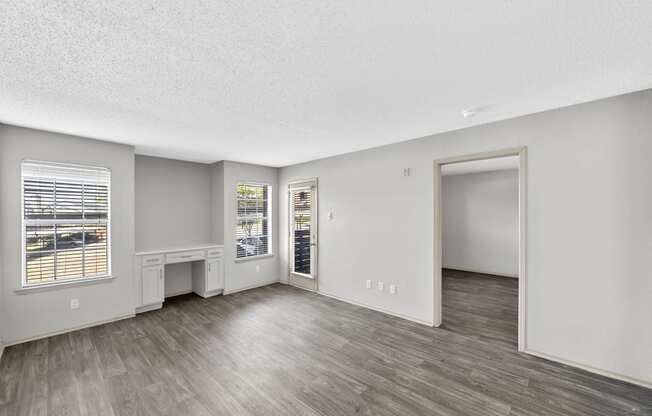 an empty living room with hardwood flooring