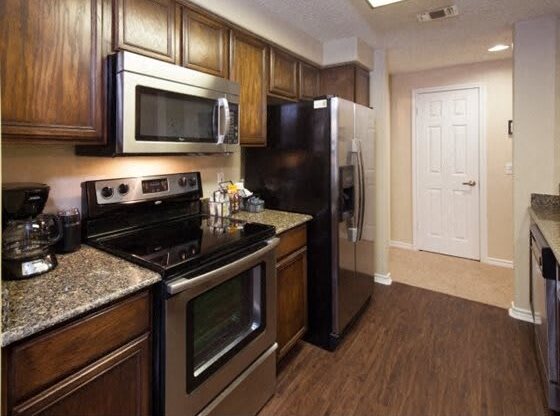 Apartments for Rent in Houston-San Montego Apartments Kitchen With Dark Wooden Cabinetry And Stainless Steel Appliances