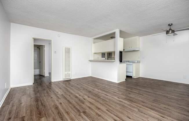 an empty living room with white walls and wood flooring