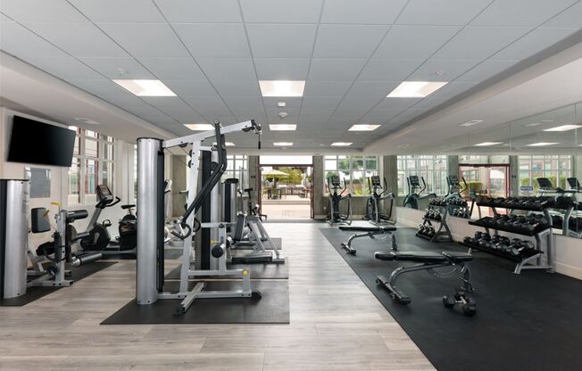 a gym with exercise equipment and a flat screen tv on the wall