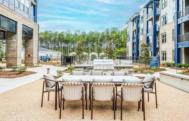an outdoor patio area with a table and chairs and a grill at Preston Ridge, Cary, 27513