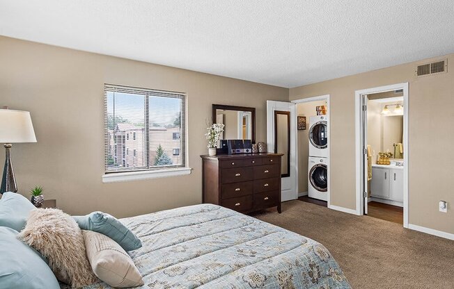 a bedroom with a bed and a washing machine