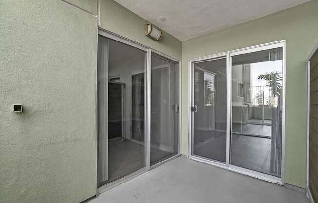 A room with a sliding glass door and a wall-mounted light fixture.