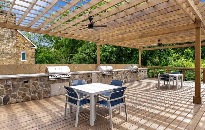 A wooden deck with a table and chairs and a grill. at Mill House at East Cobb, Marietta, GA
