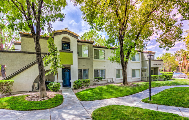 A tree in front of a building with a blue door.
