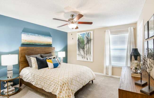 a bedroom with a bed and a ceiling fan at Crossgates Apartment Homes, Starkville, Mississippi