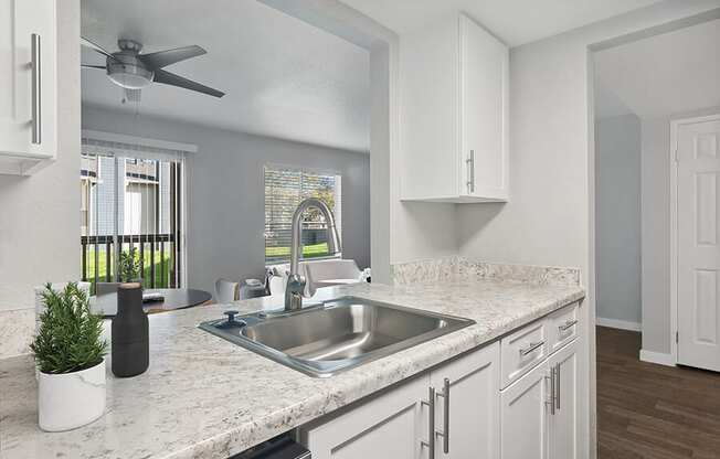 Model Kitchen with White Cabinets and Wood-Style Flooring at Overlook Point Apartments in Salt Lake City, UT.