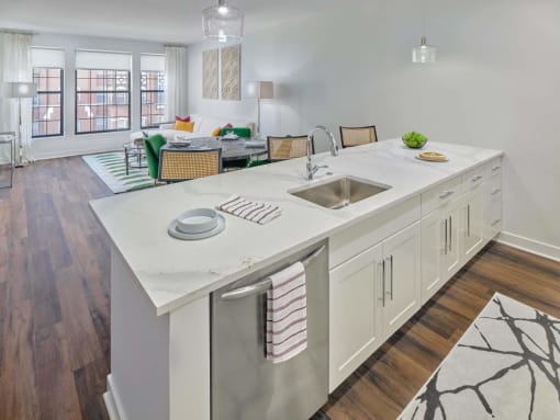 an open kitchen with a large island and a living room at The Encore at Ingram Manor, Pikesville, MD