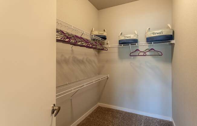 an empty closet with two shelves and two baskets on a rack