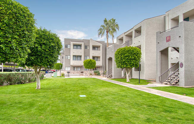 El Encanto outside view with nice lush grass area with trees around