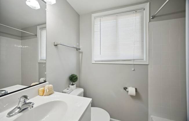 a bathroom with a white sink and toilet next to a white bathtub