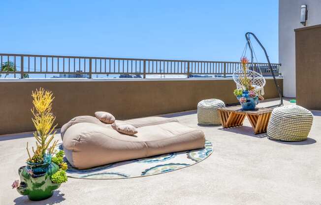 a terrace with a bean bag chair and tables on a roof