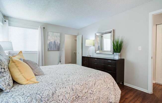 A bedroom with a bed, dresser, and mirror.