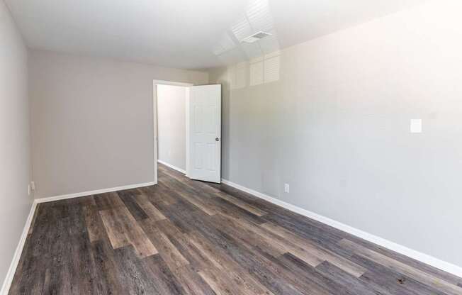 an empty room with wood flooring and a white door