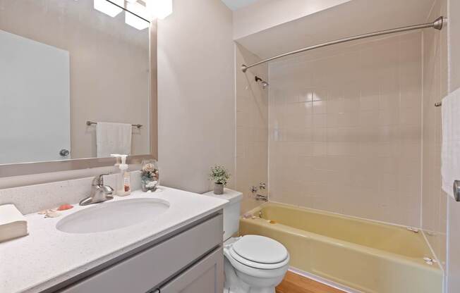 A bathroom with a sink, toilet, and bathtub.