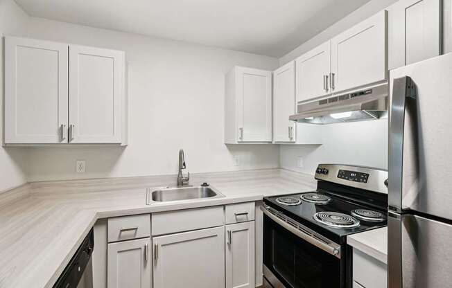A kitchen with white cabinets and appliances.
