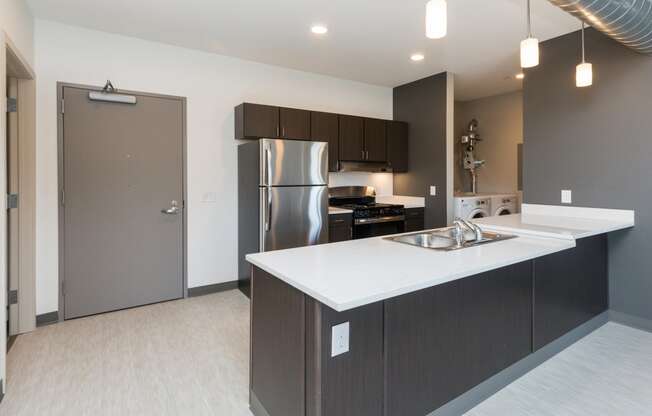 Modern open-concept kitchen and living area with stainless steel appliances.