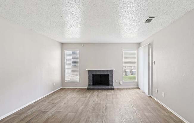 A6 living room with a fireplace and vinyl wood flooring Windridge on the Parkway apartments in Dallas, TX.