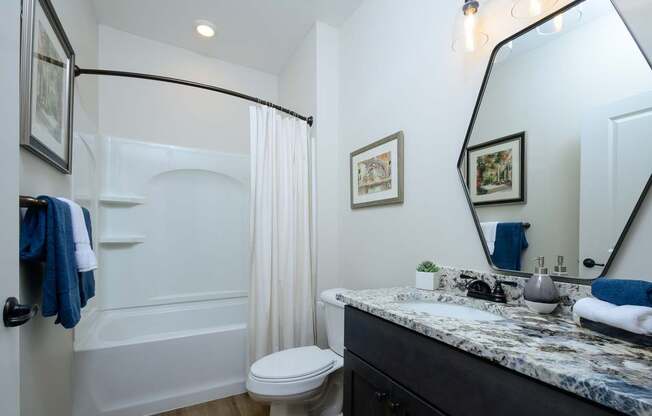 A bathroom with a white tub, toilet, and sink.