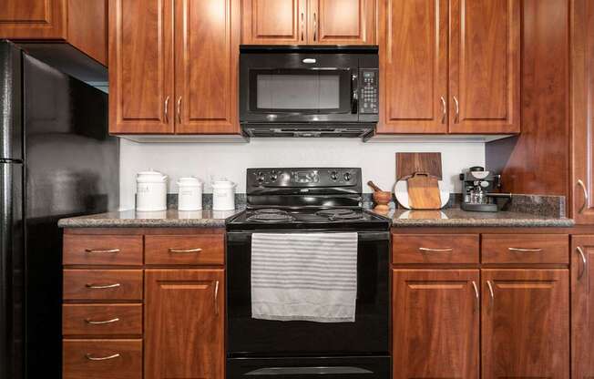 A kitchen with wooden cabinets and a black stove top oven.