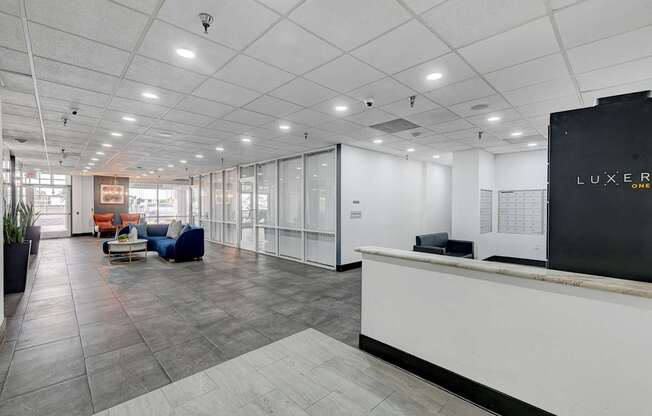 A reception area with a white reception desk and a sign that says "LUXER".