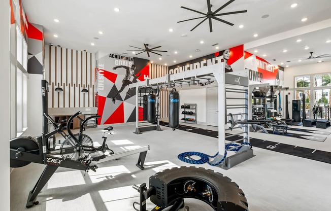 A gym with a variety of equipment including a treadmill, weights, and a bicycle.