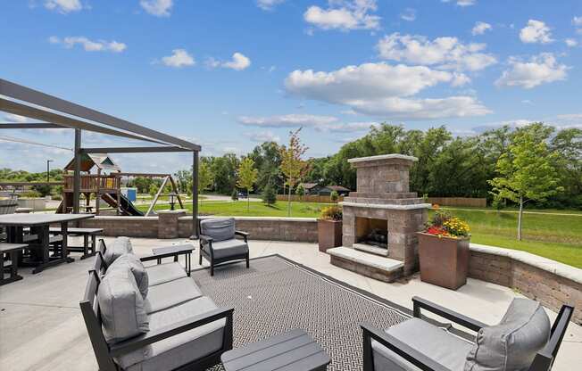 a large patio with furniture and a stone fireplace