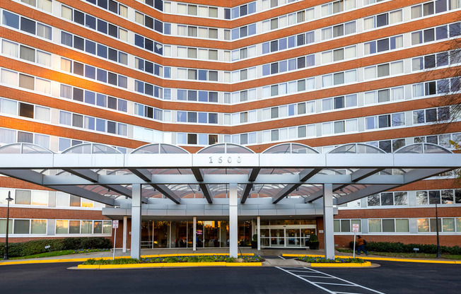 a large building with a covered entrance and a parking lot