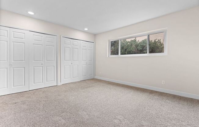 an empty room with three closets and a window