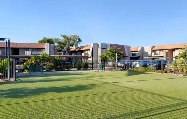 A grassy area in front of a building with a fence at Denim Scottsdale, Scottsdale, AZ
