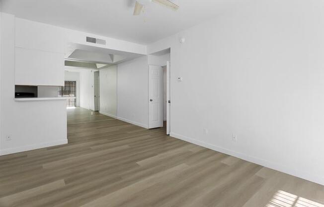 A room with wooden flooring and white walls.