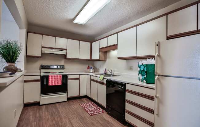 Grand Forks Primrose Apartments. A  kitchen with white cabinets and black and white appliances