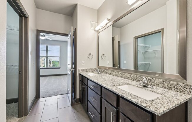 A bathroom with a sink, mirror, and a large window.