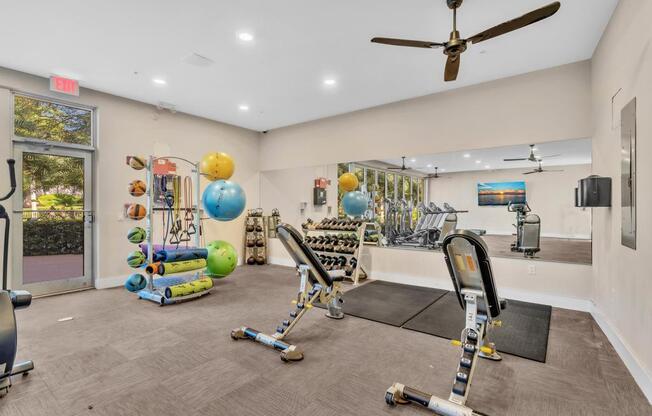 A gym with a variety of equipment including weights and exercise balls.