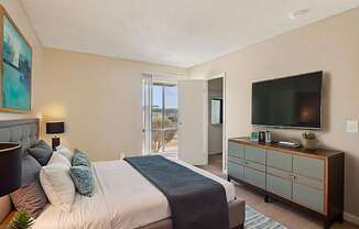 A bedroom with a bed, nightstand, and a television.
