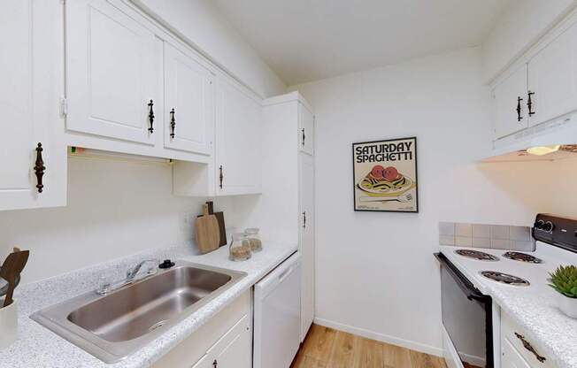 A kitchen with white cabinets and a poster that says "Saturday Spaghetti".