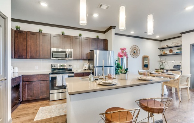 a kitchen with a bar and a dining area with chairs