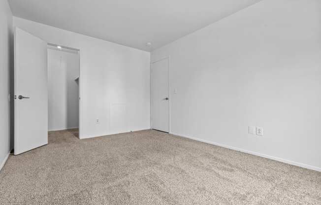 a bedroom with white walls and carpet