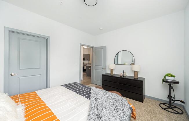 a bedroom with a bed and a dresser with a mirror