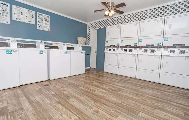 Onsite laundry room with blue walls washer and dryers at Maplewood apartments in Shreveport, LA.