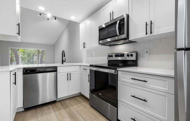 A modern kitchen with stainless steel appliances and white cabinets.