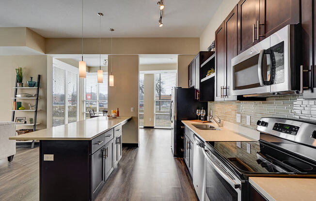 Kitchen with white tabletops, dark brown cabinets, and modern appliances