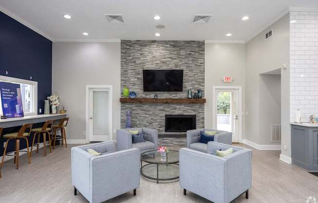 A living room with a grey couch, a fireplace, and a television.